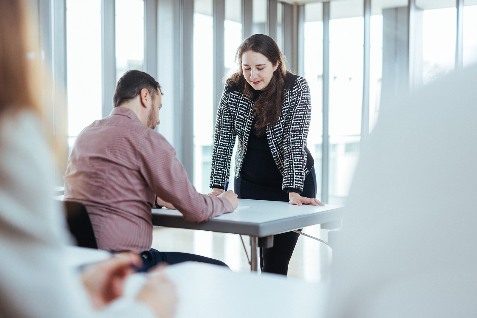 Trainer giving individual guidance to participant during European Patent Litigation Certificate course – practice-oriented legal education in focus